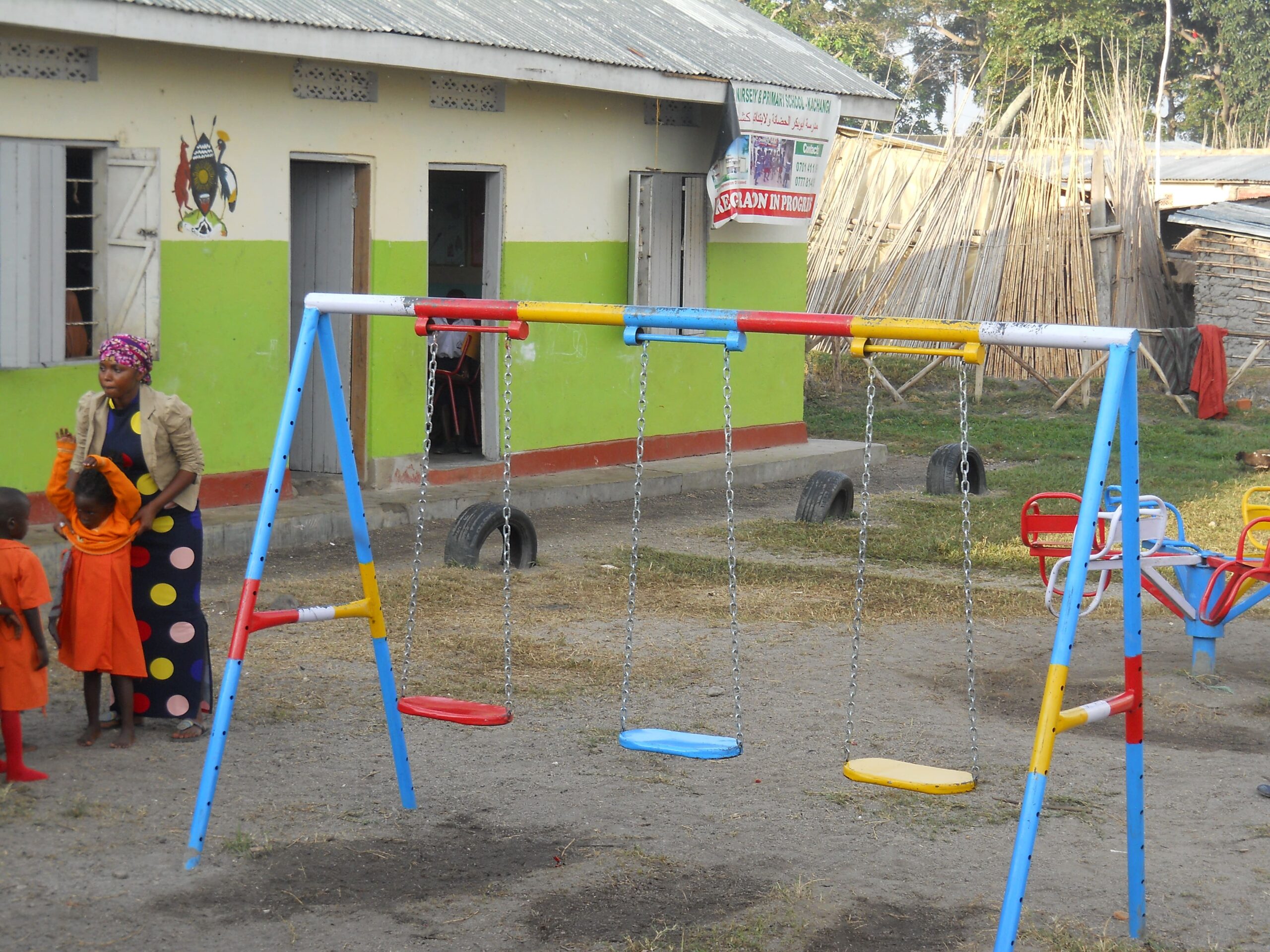 "A joyful view of the school compound in Kalangala District, Kachanga Fishing Community, featuring swings for children's play."